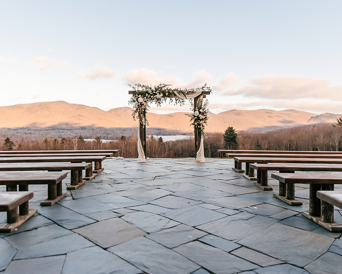 a wedding ceremony with benches and a view of mountains
