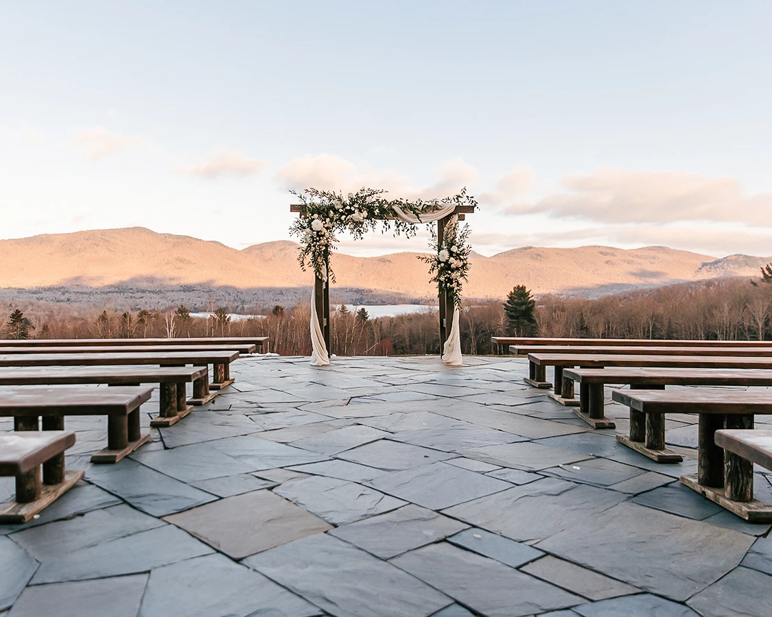 a wedding ceremony with benches and a view of mountains