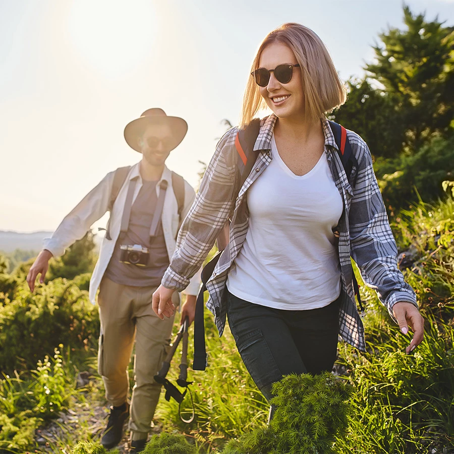 a man and woman walking on a trail