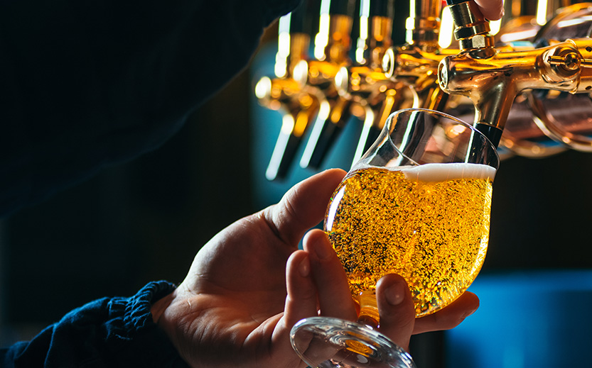 a person holding a glass of beer