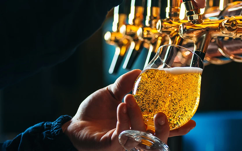 a person holding a glass of beer