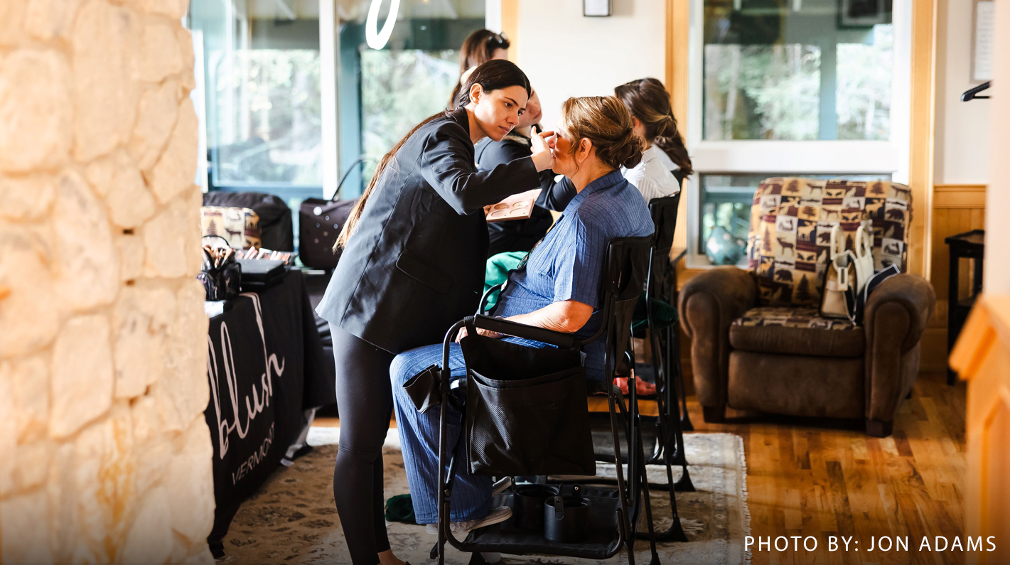 a woman getting makeup done by a woman