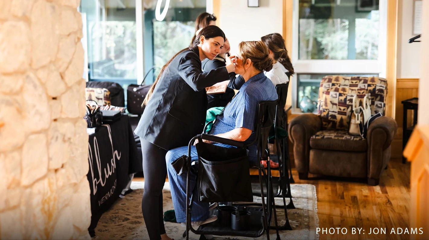 a woman getting makeup done by a woman