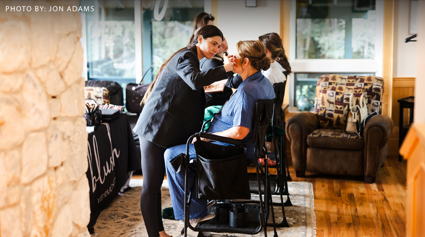 a woman getting makeup done by a woman