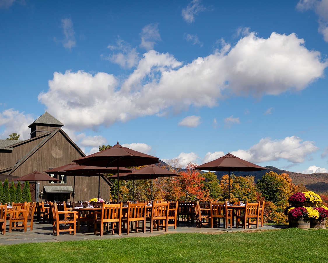 a table and chairs outside with umbrellas