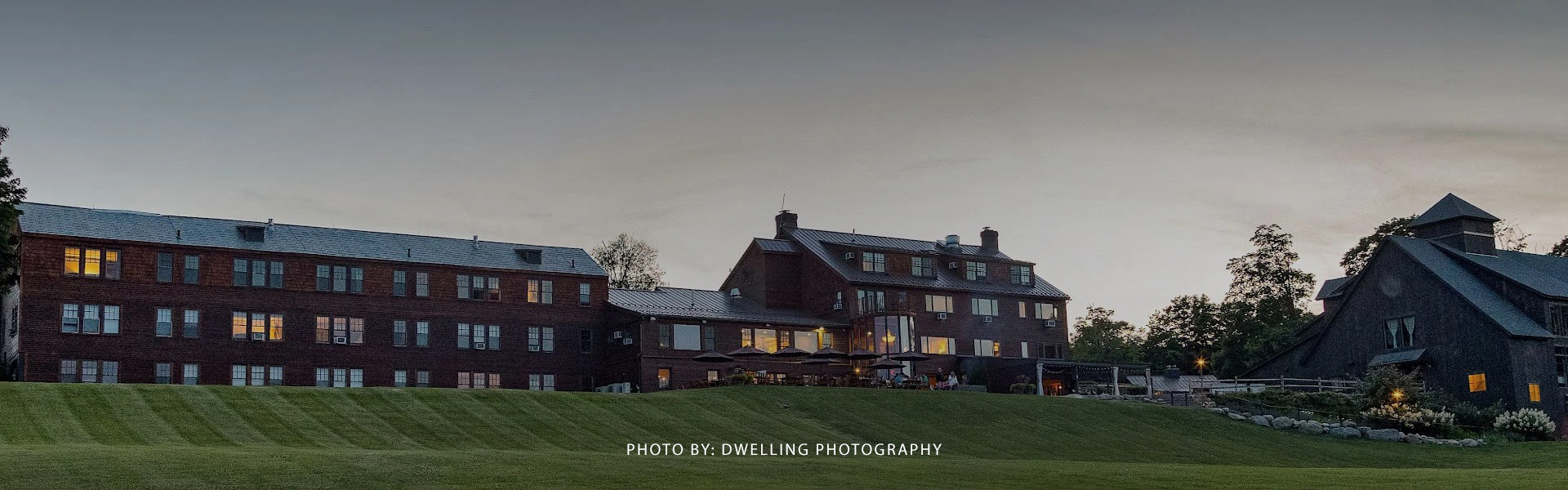 a large building with a lawn and a hill