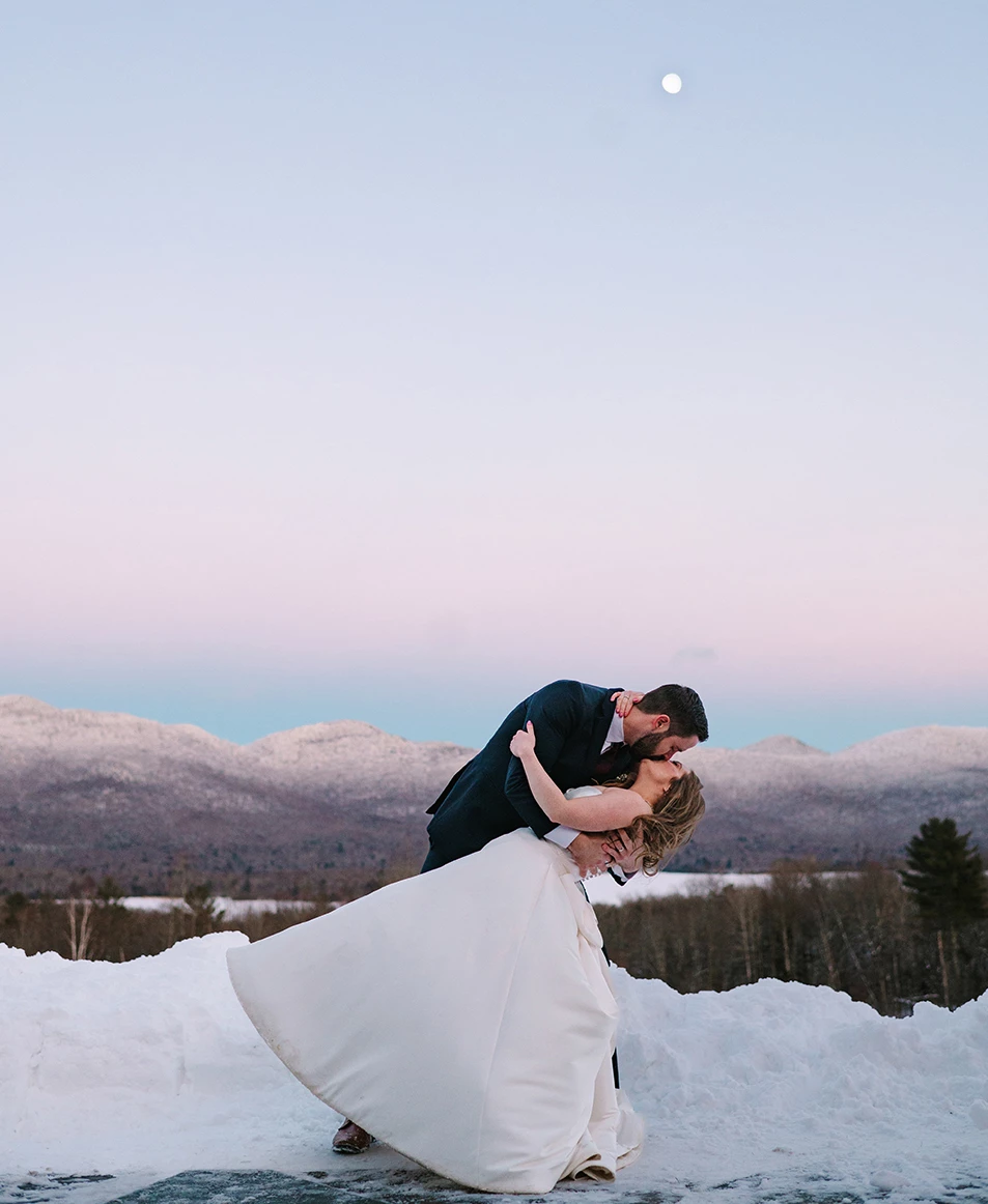 a man and woman kissing in the snow