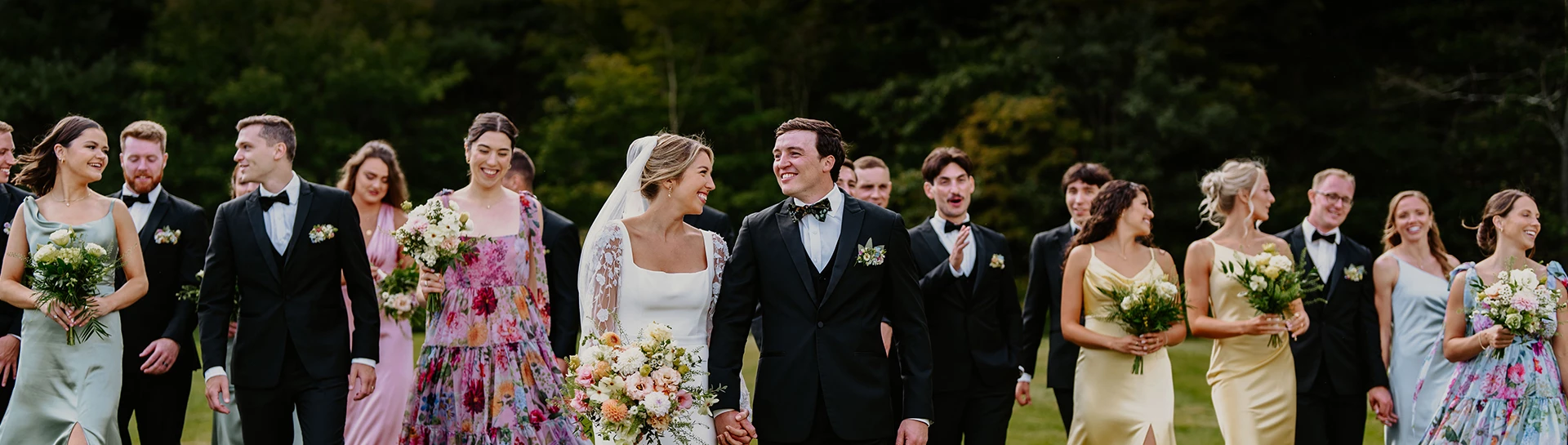 a man and woman in a white dress and tuxedo holding hands