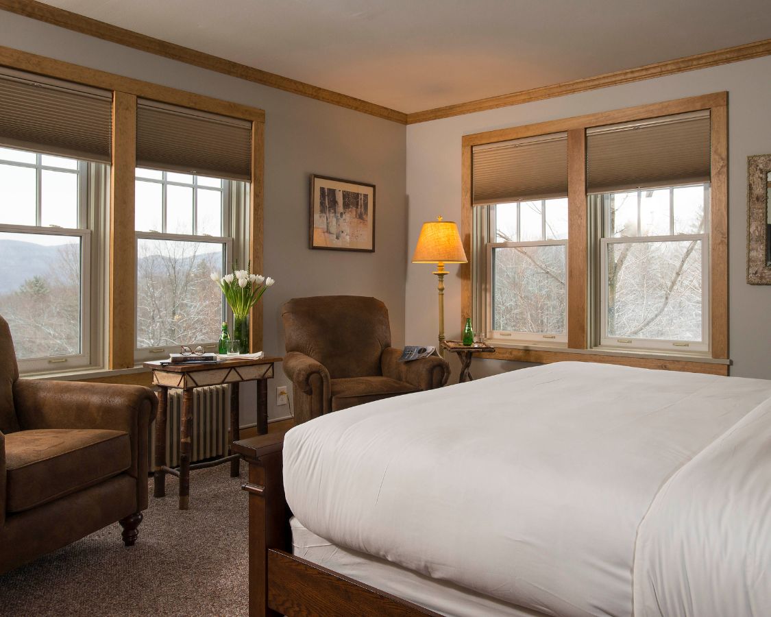 a bedroom with a bed and chairs