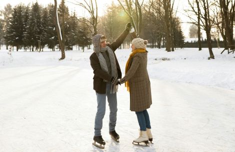 a man and woman ice skating in the snow