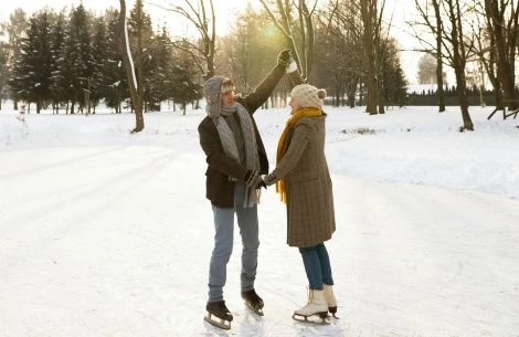 a man and woman ice skating in the snow