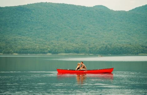 a couple in a red canoe on a lake