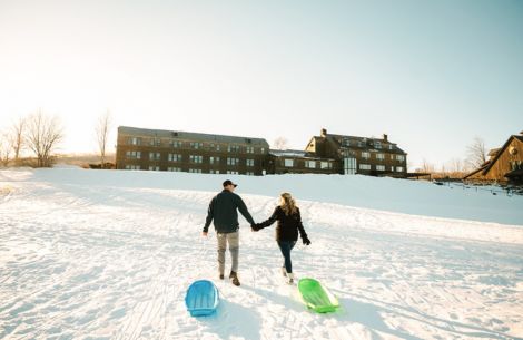a man and woman holding hands in the snow