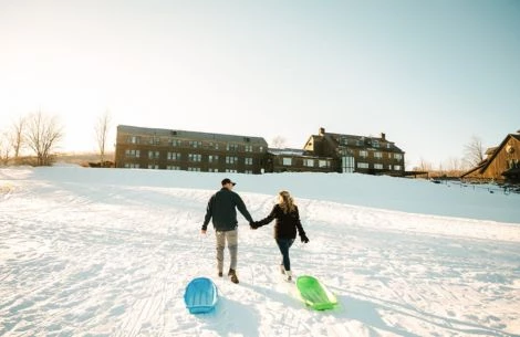 a man and woman holding hands in the snow
