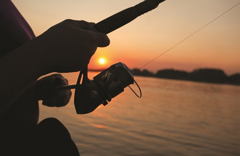 a person fishing at sunset