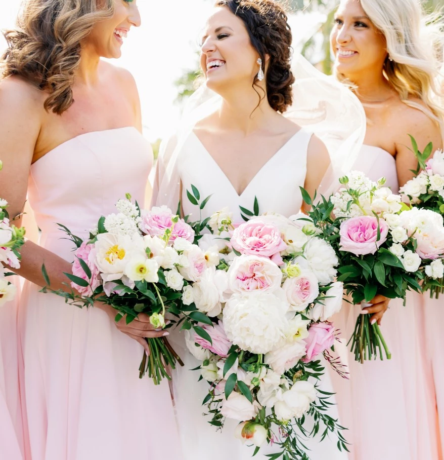 a group of women in dresses holding flowers