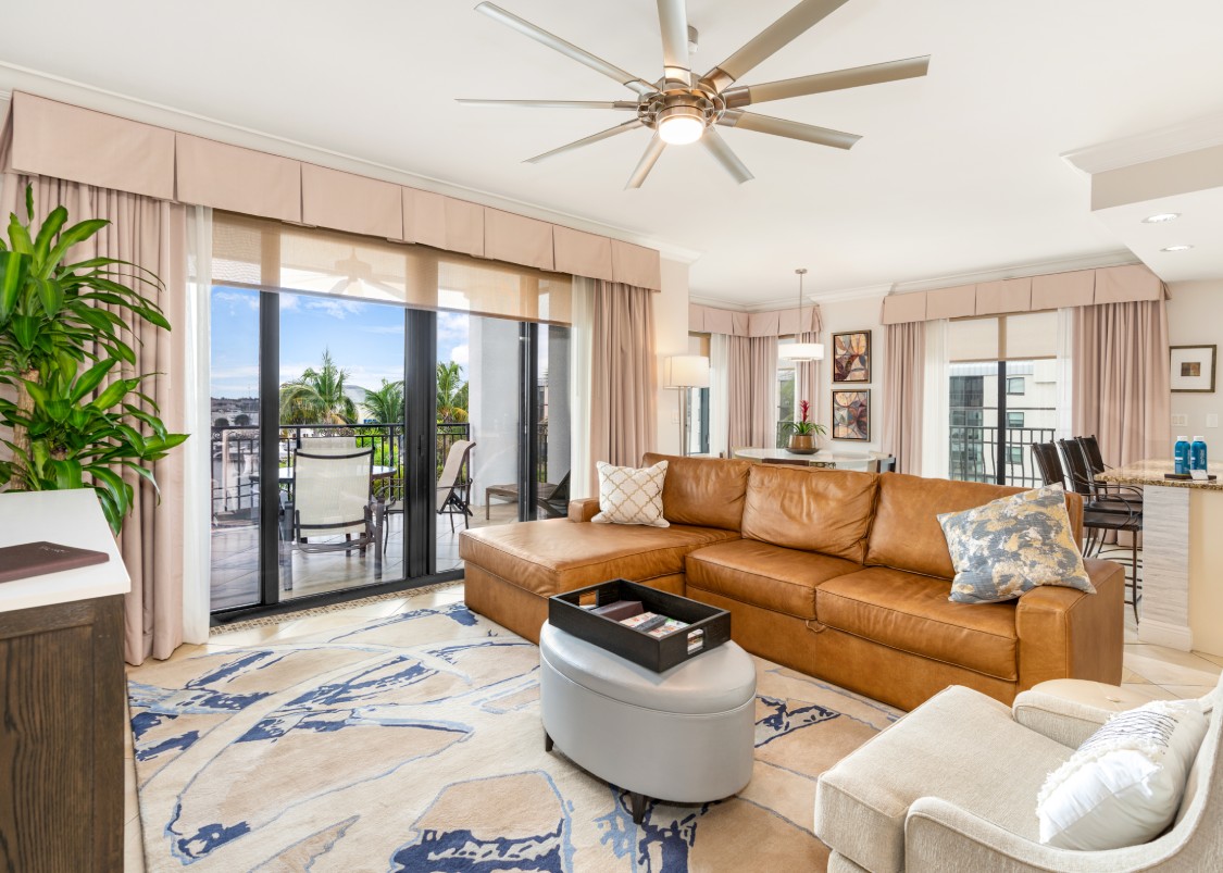 a living room with a leather couch and a fan