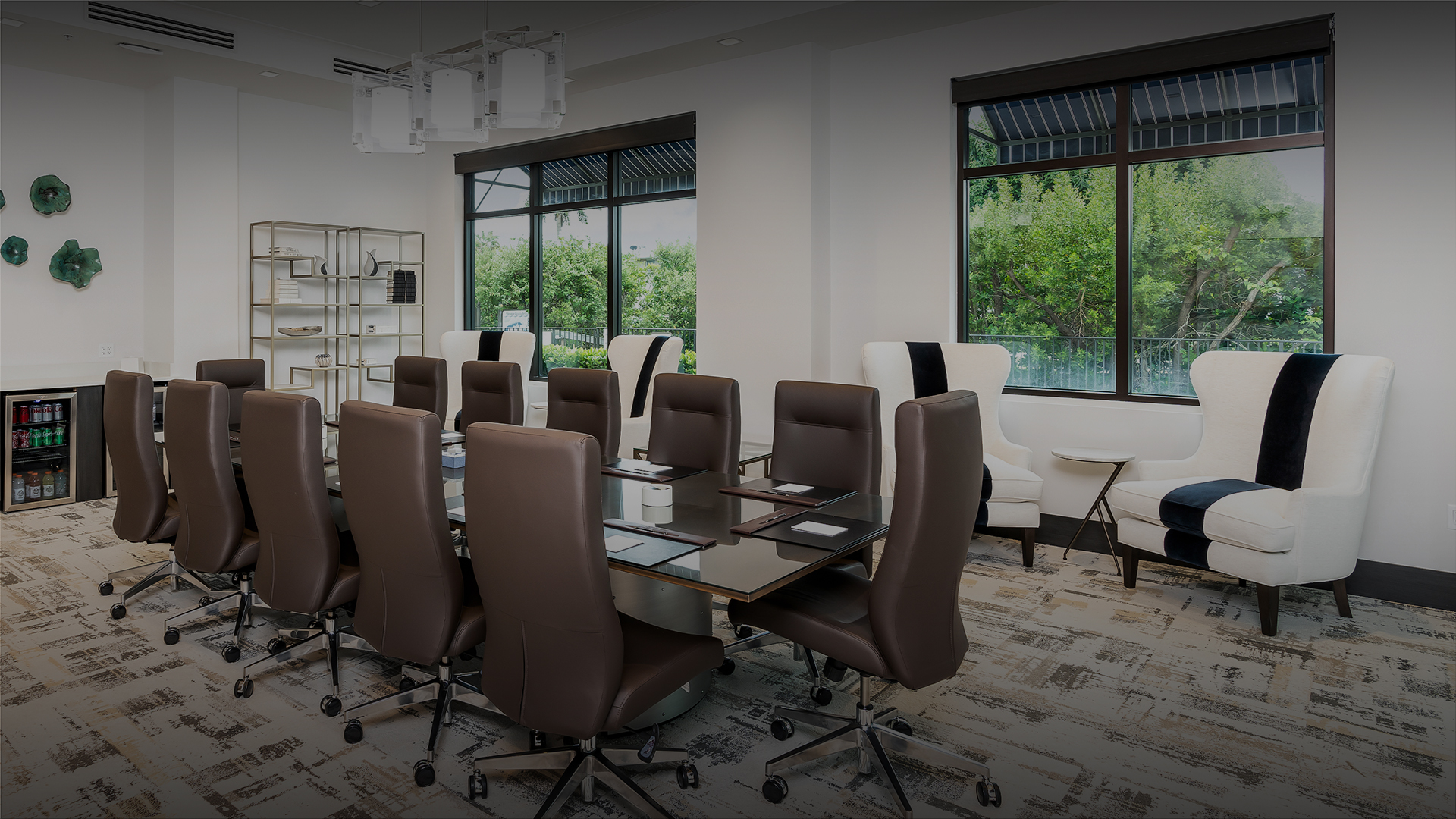 a meeting room with a glass table and brown chairs