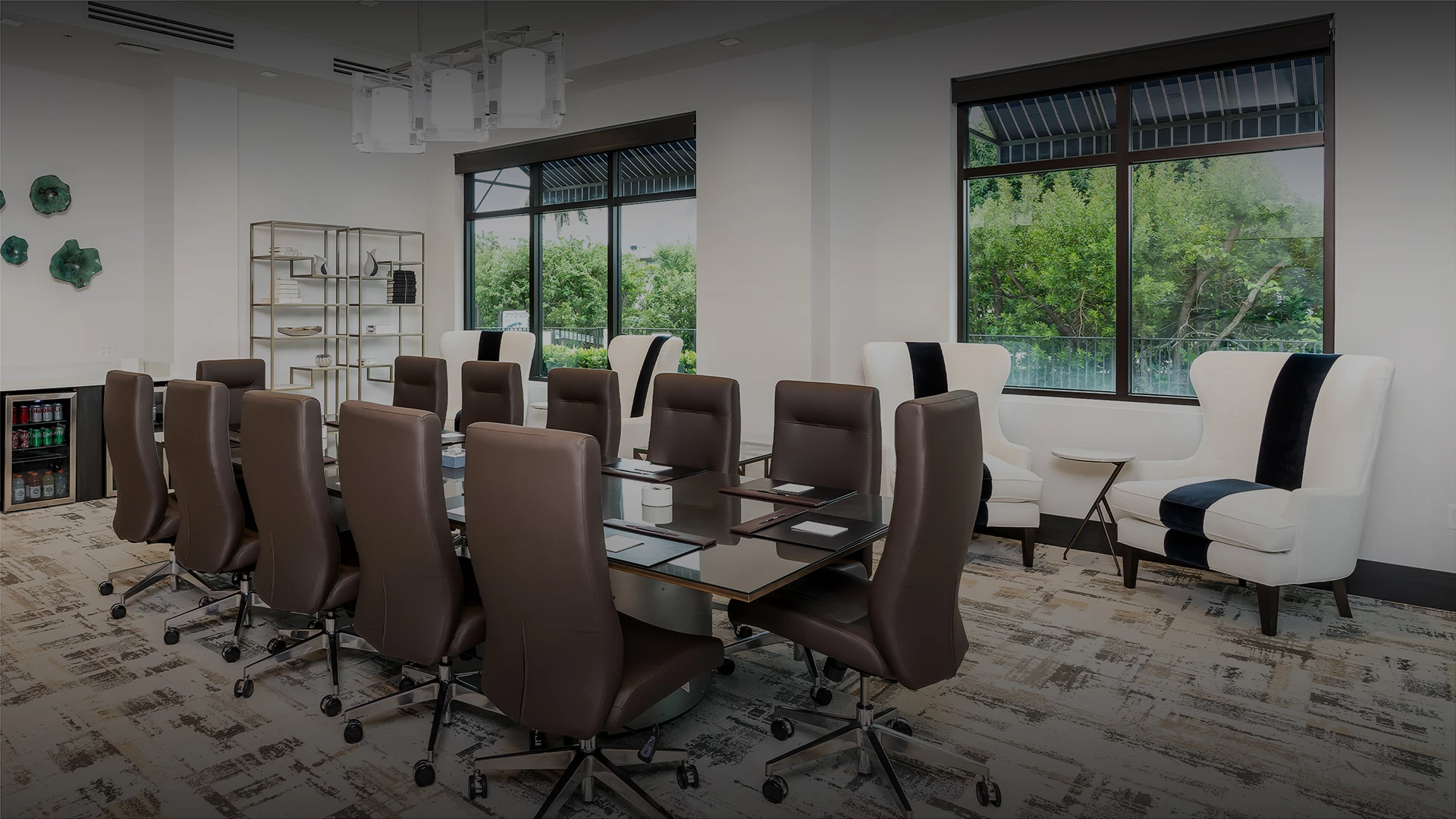 a meeting room with a glass table and brown chairs