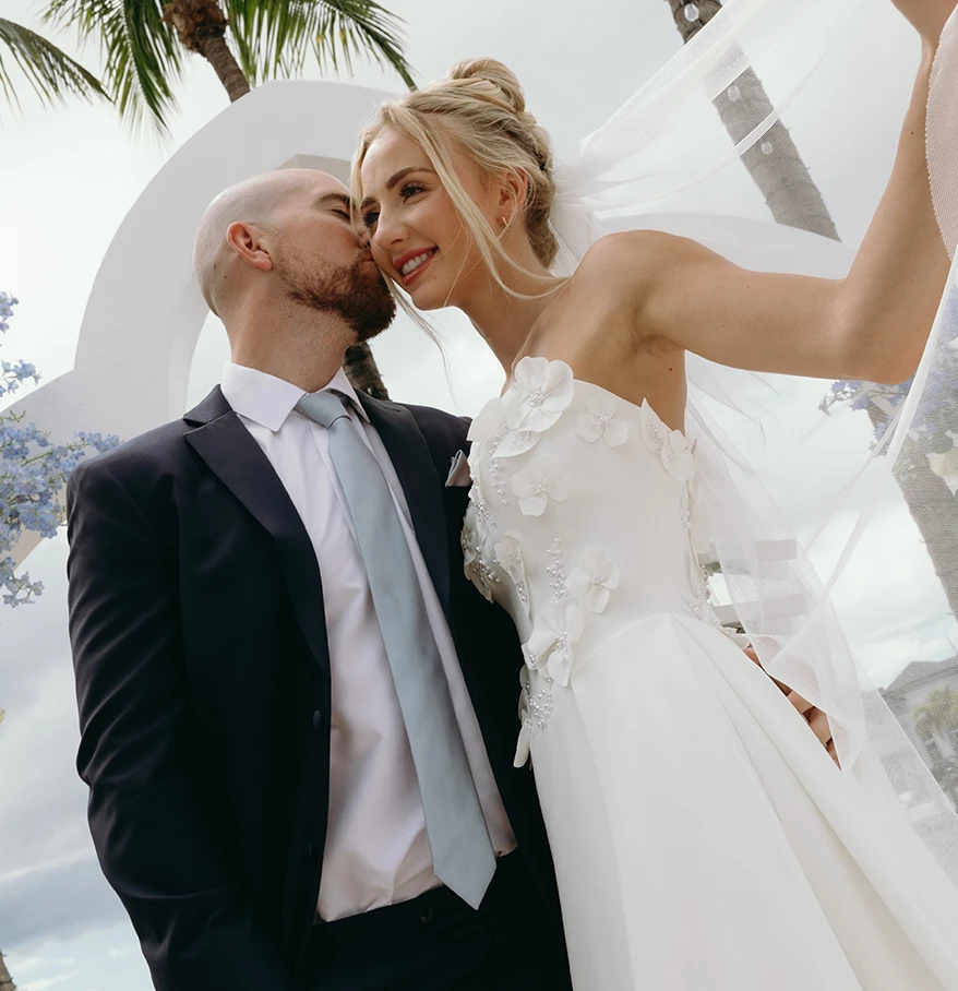 a man kissing a woman in a wedding dress