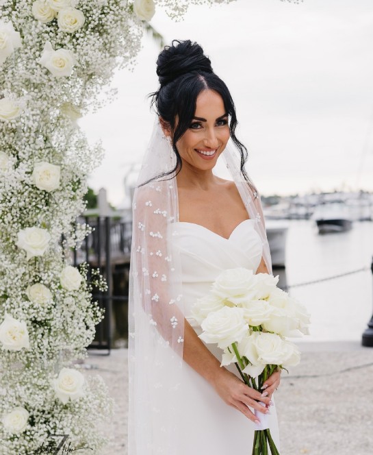 a woman in a white dress holding a bouquet of white flowers