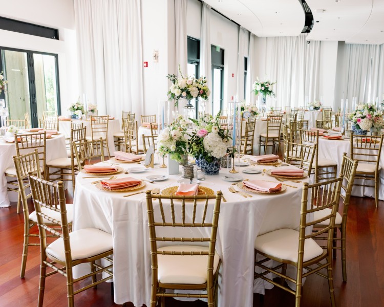 a set table with white tablecloths and white chairs