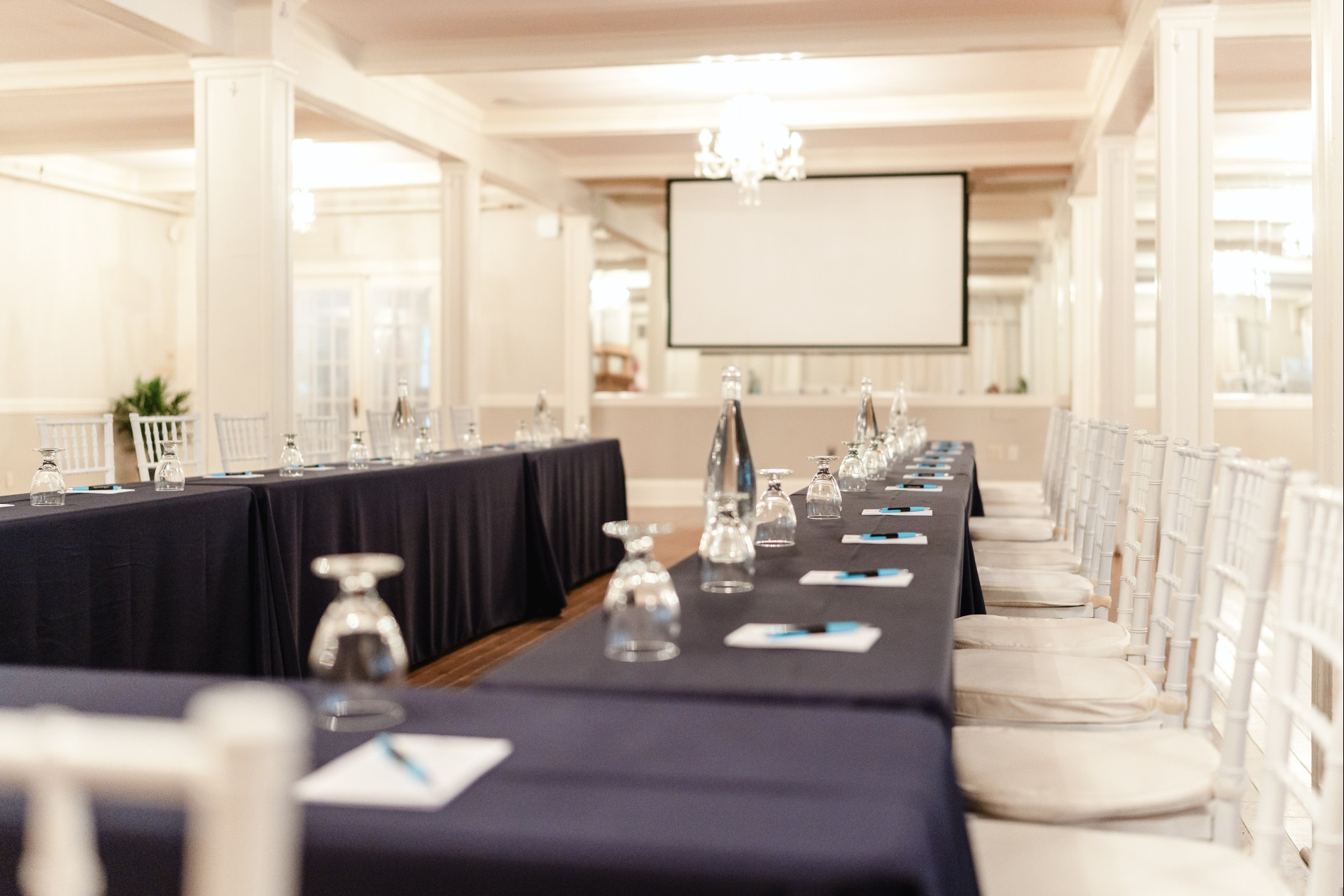 a long table with black tablecloths and glasses on it