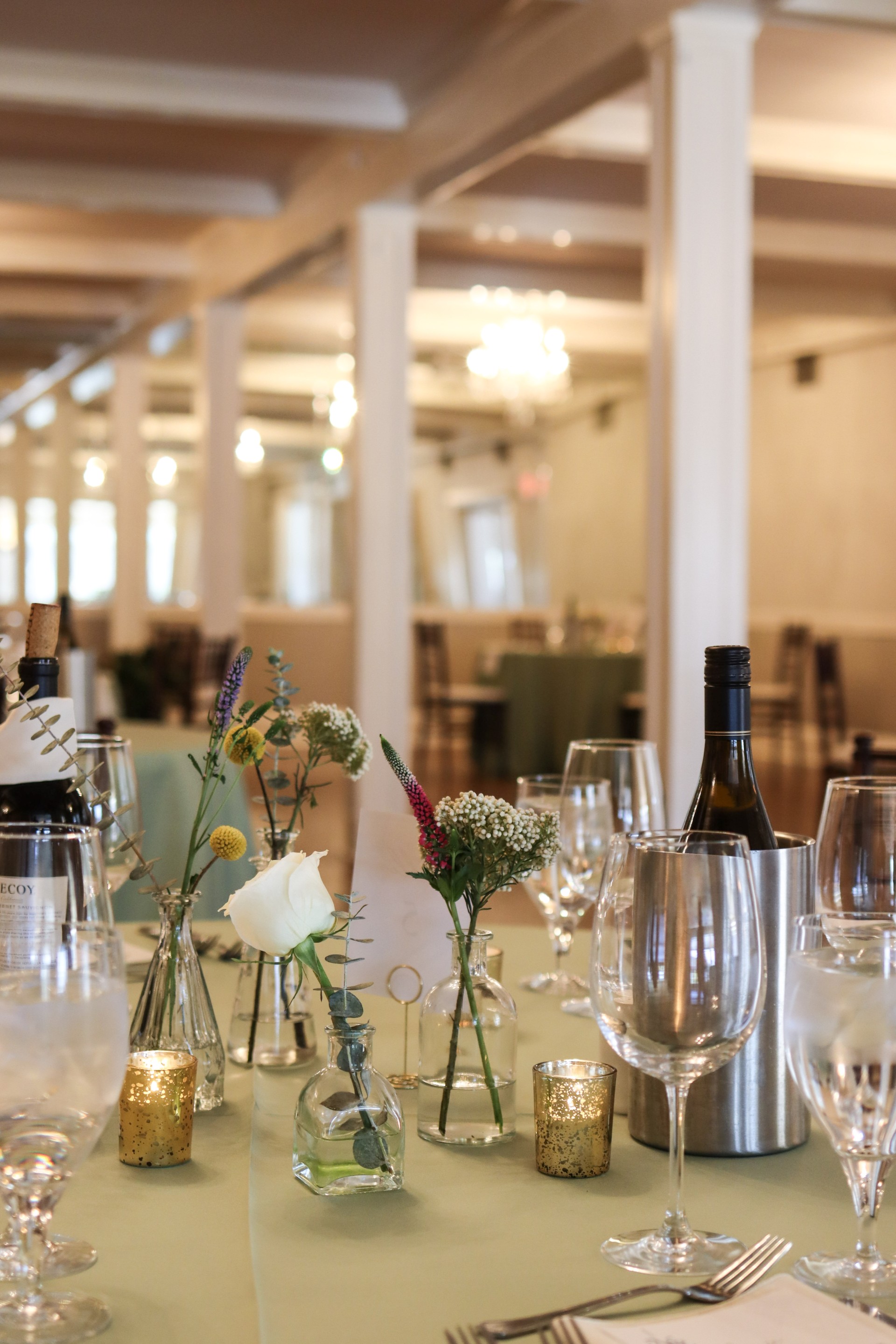 a table with wine glasses and flowers