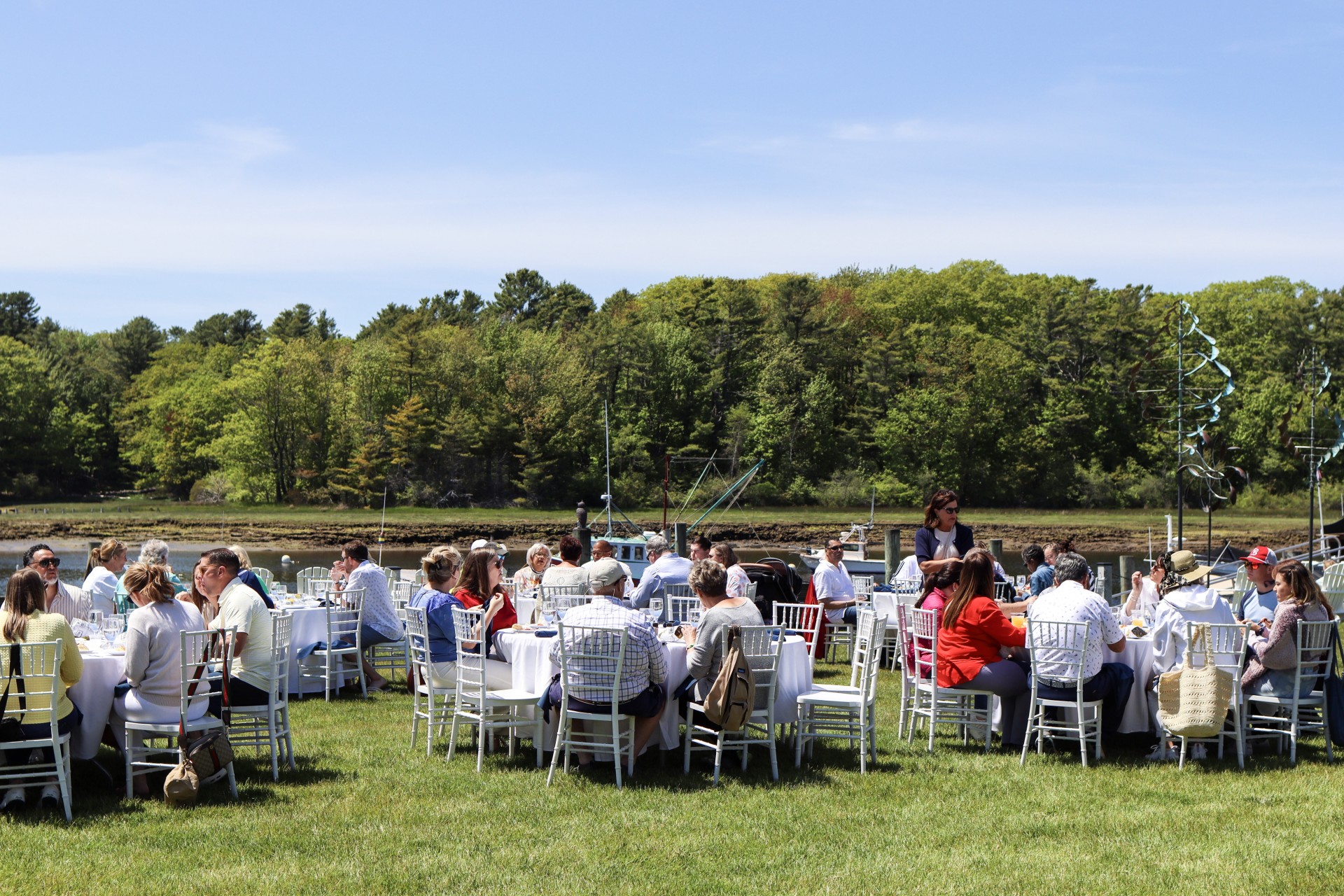 a group of people sitting at tables outside