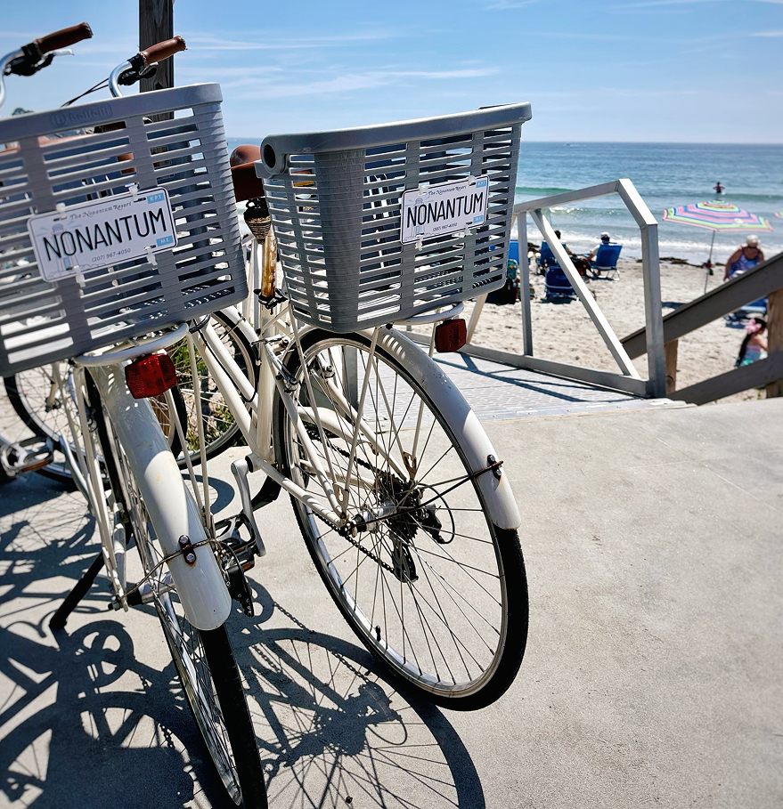 a bicycle parked on a sidewalk with a beach in the background