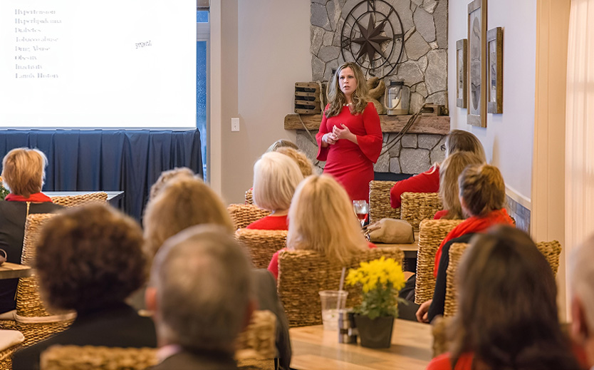 a woman in a red dress standing in front of a group of people