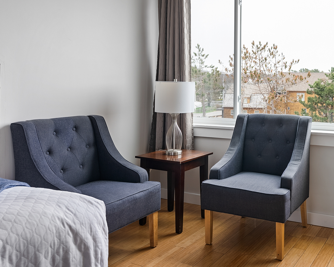 a room with two chairs and a lamp