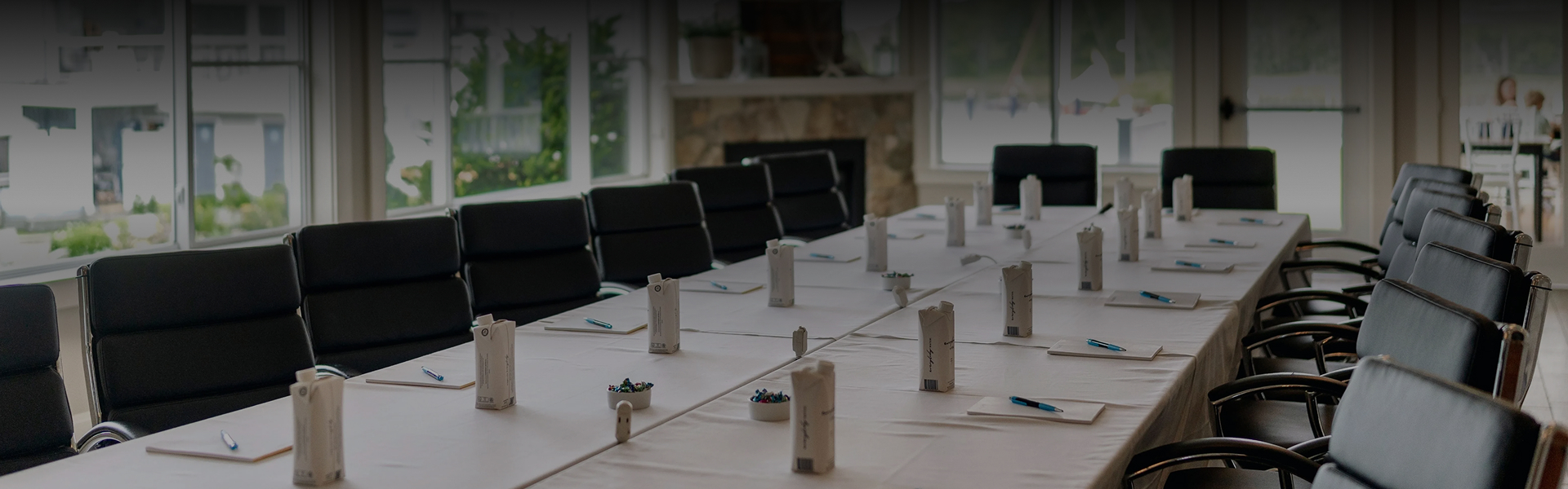 a long table with white tablecloths and pens and pencils