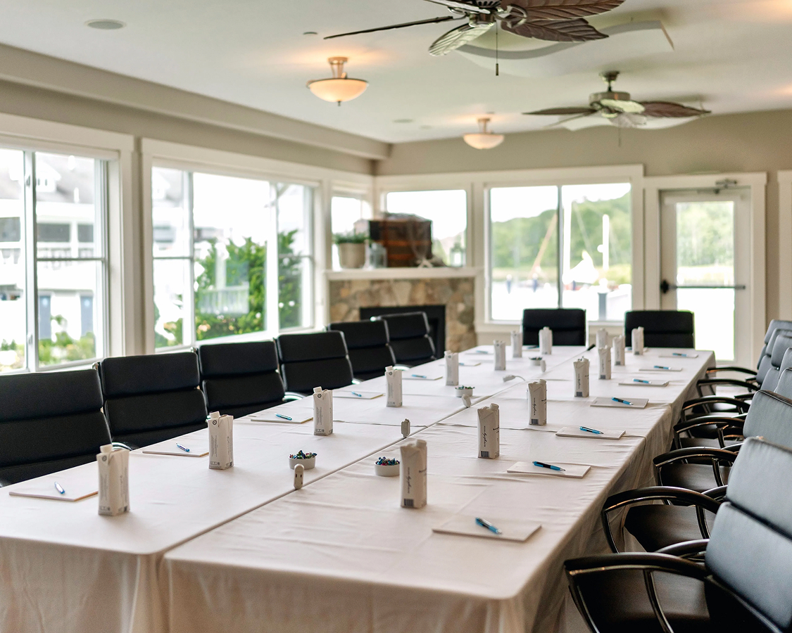 a long table with white tablecloths and pens on it
