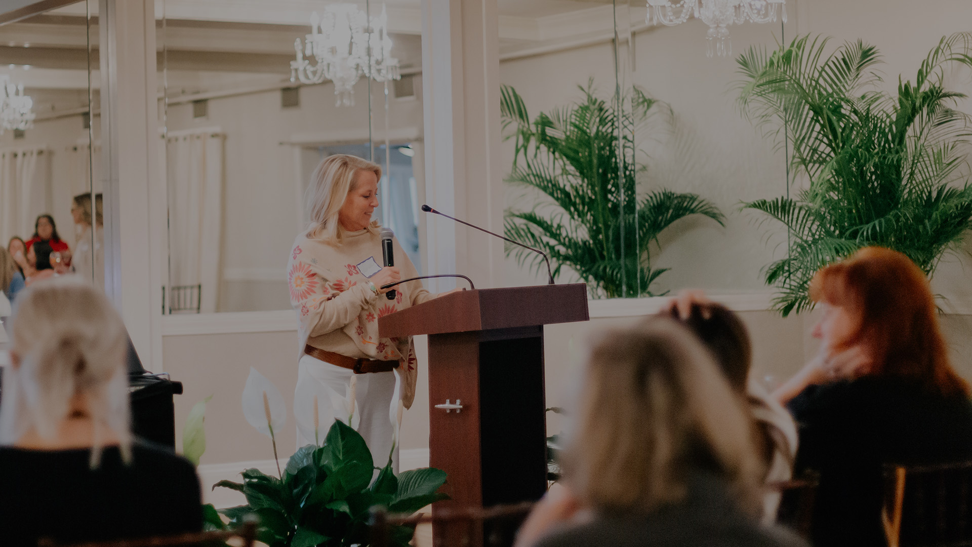 a woman standing at a podium with a microphone