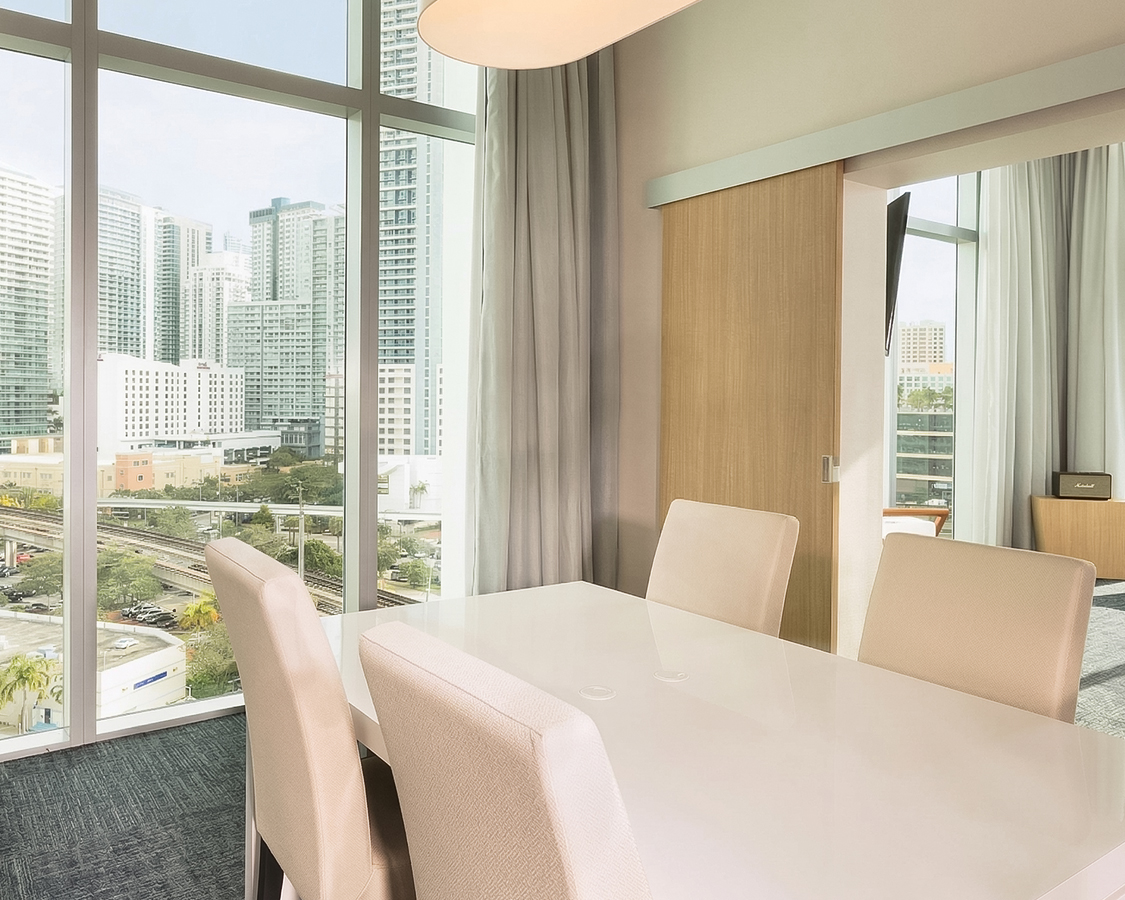 a dining table with chairs in a room with a view of a city