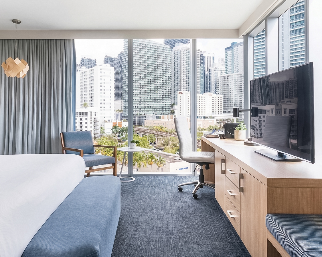 a room with a bed and a desk and chairs