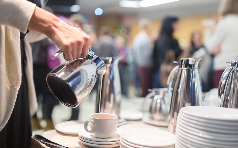 a person pouring liquid into a cup