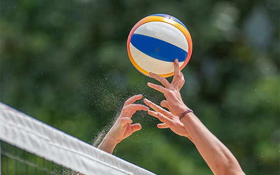 a person reaching for a beach volleyball