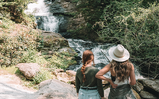 two women looking at a waterfall