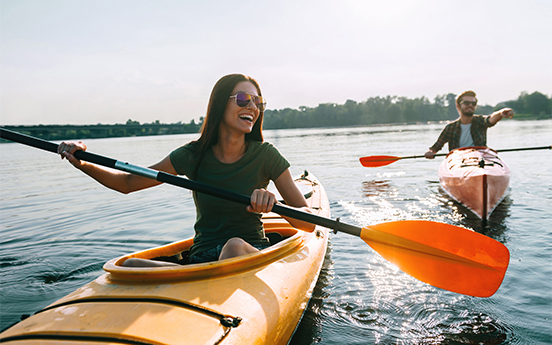 a woman in a kayak with a man in the background