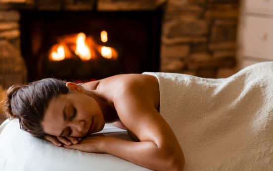 a woman lying on a bed with her eyes closed