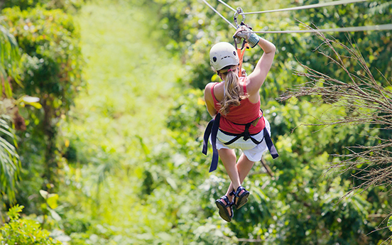 a woman in a helmet on a zip line