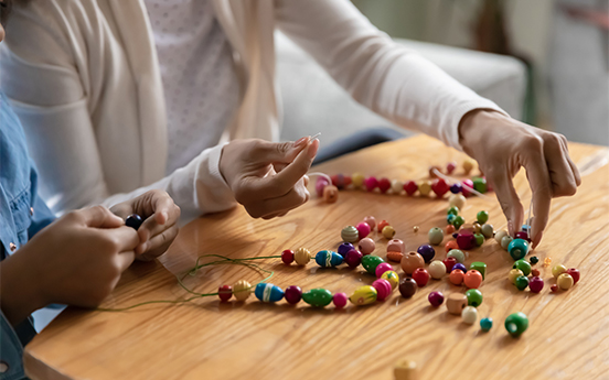 a group of people making beads