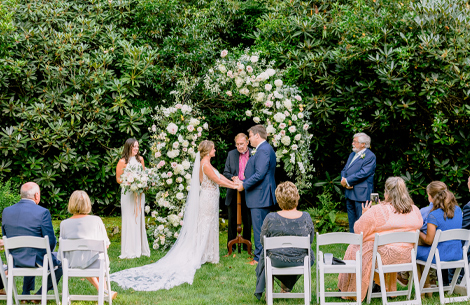 a bride and groom under a floral arch