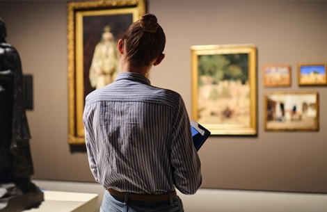 a woman looking at a painting