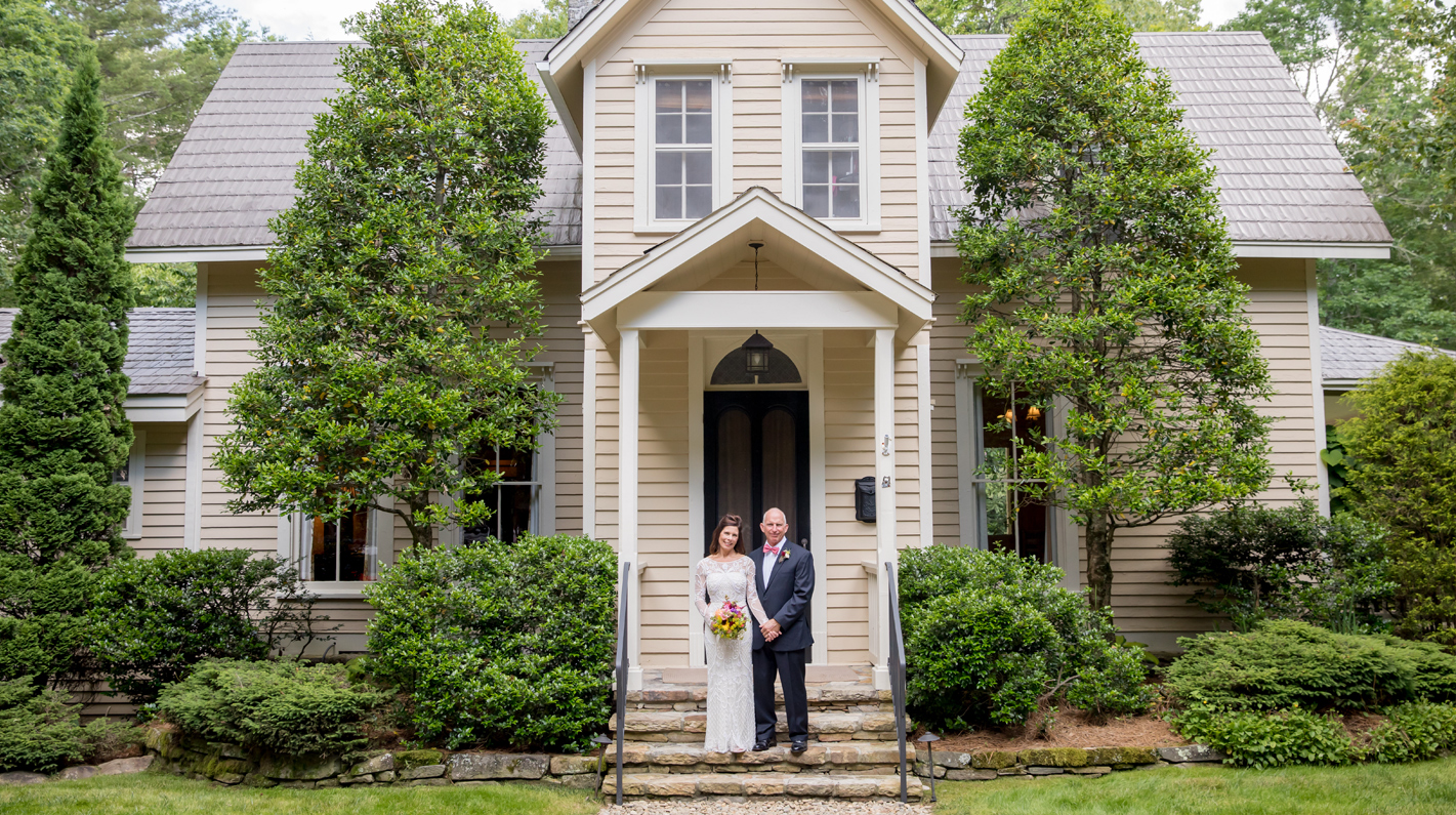 a man and woman standing on stairs in front of a house
