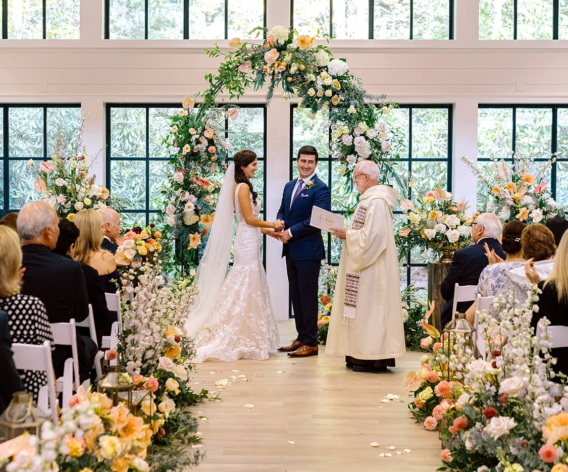 a bride and groom holding hands in a wedding ceremony