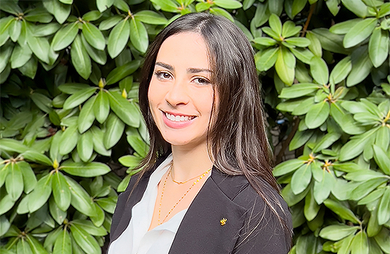 a woman smiling in front of a bush