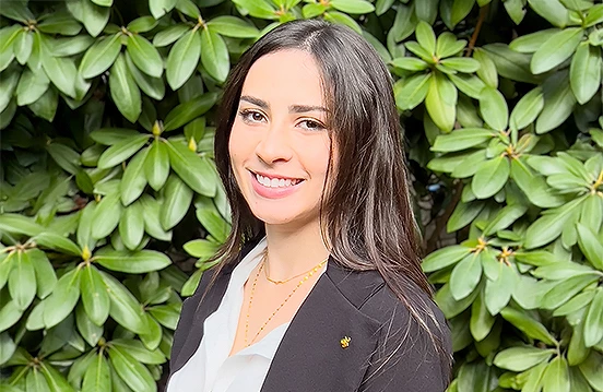 a woman smiling in front of a bush